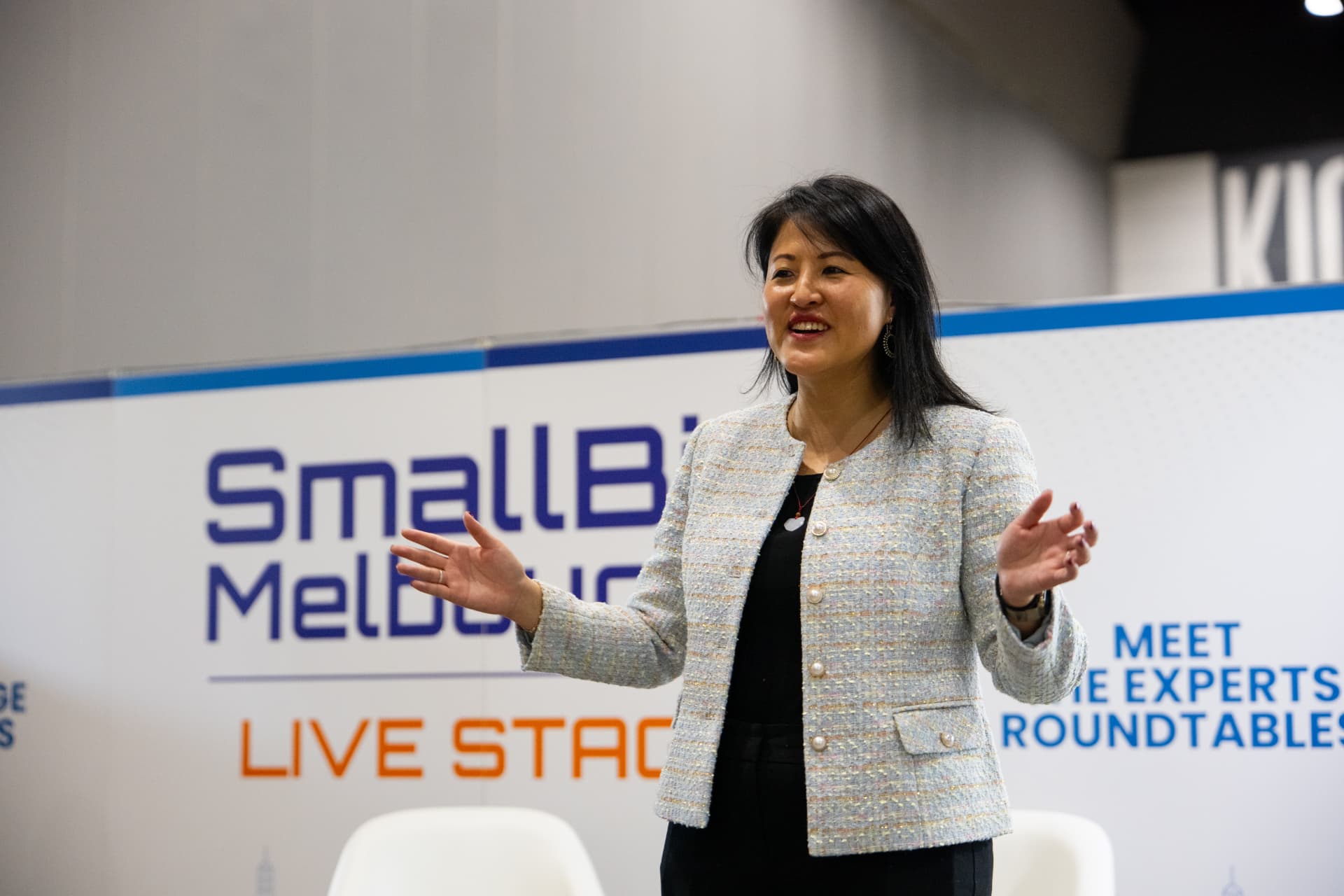 Lucy Lin speaking with open hands on stage