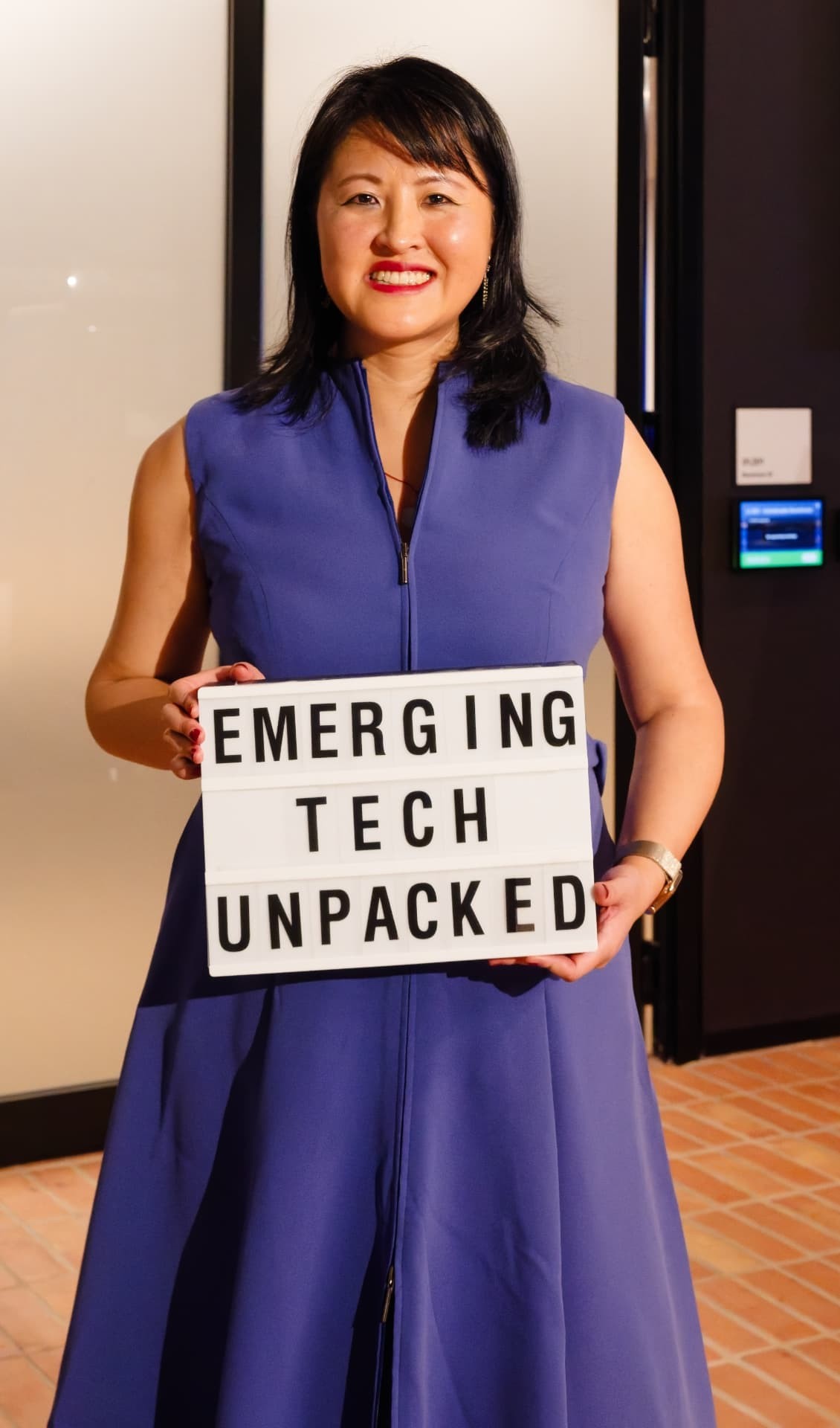 Lucy Lin holding an Emerging Tech Unpacked lightbox sign